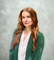 Professional pic of a red head woman in a green jacket